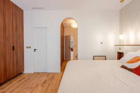 Chambre avec arche murale nude et tête de lit minimaliste