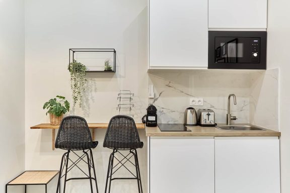 Cuisine lumineuse et minimaliste, soulignée par des contrastes sobres et un mobilier parfaitement intégré